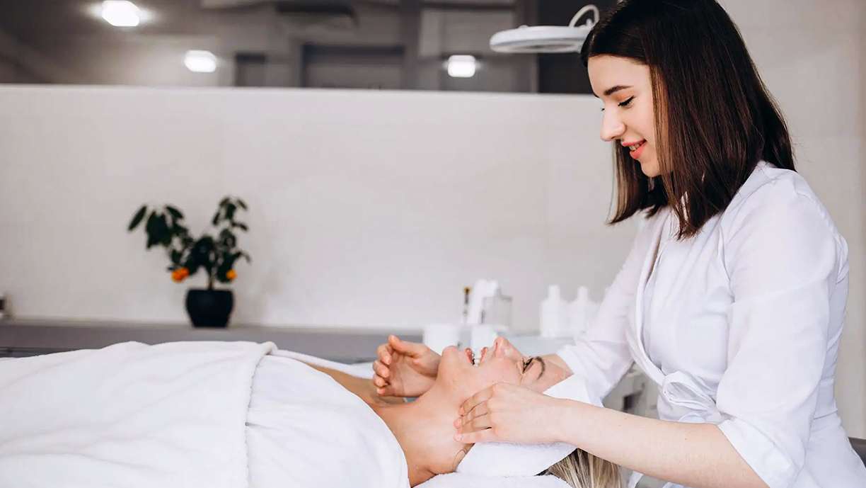 Esthetician with client during waxing session